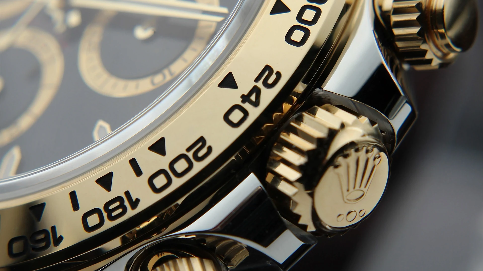 Close detail of a Rolex Cosmograph Daytona crown and bezel.